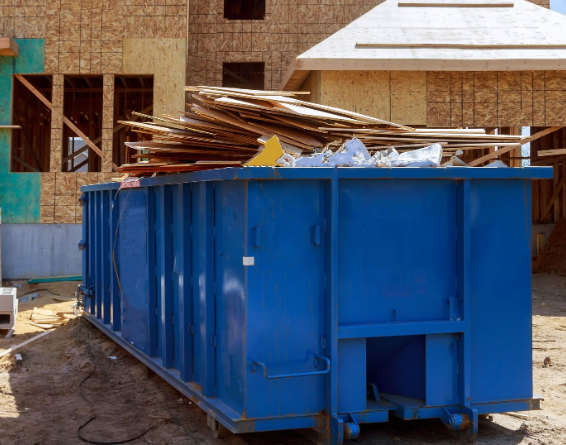 Blue dumpster at construction site loaded with construction waste
